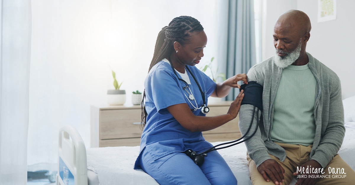 Senior man being assessed at a hospital by a nurse, taking his vitals | Navigating Medicare & Hospital Stays